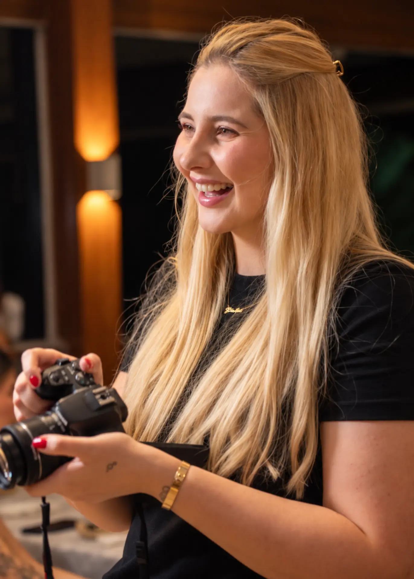 Giulia Barbosa, à frente da Agência GS, segurando uma câmera fotográfica